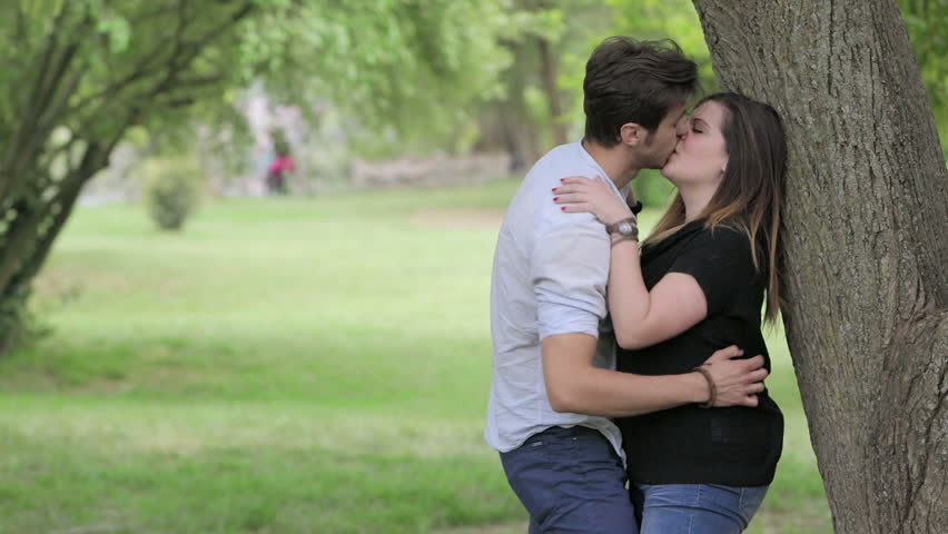 Lovers Kissing Sitting On The Bench In A Public Park Couple In Love Stock Footage Video