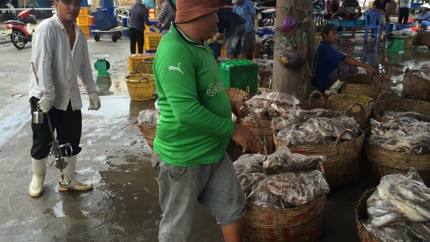  Unidentified people unload a fishing boat at a local port, time lapse