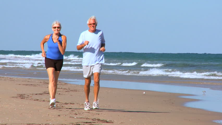 Healthy Senior Couple Enjoying Retirement Leisure On The Beach Filmed ...