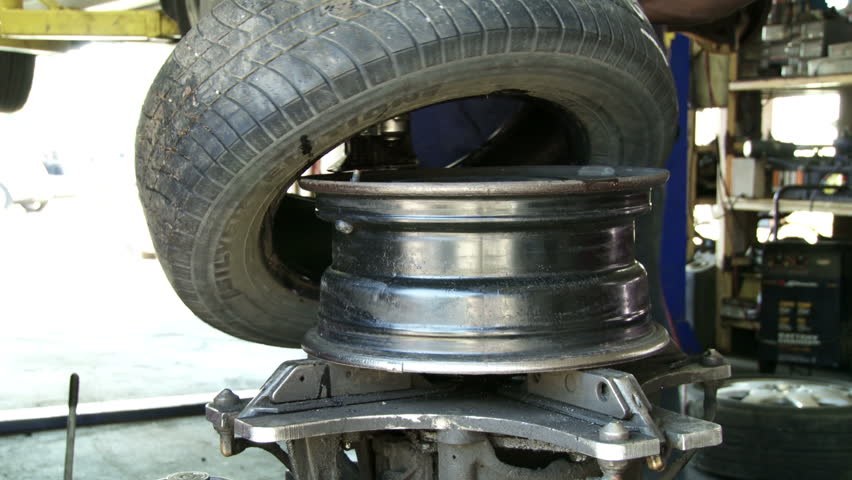 Car Tire Being Put Onto Wheel Rim In Auto Repair Shop. Stock Footage
