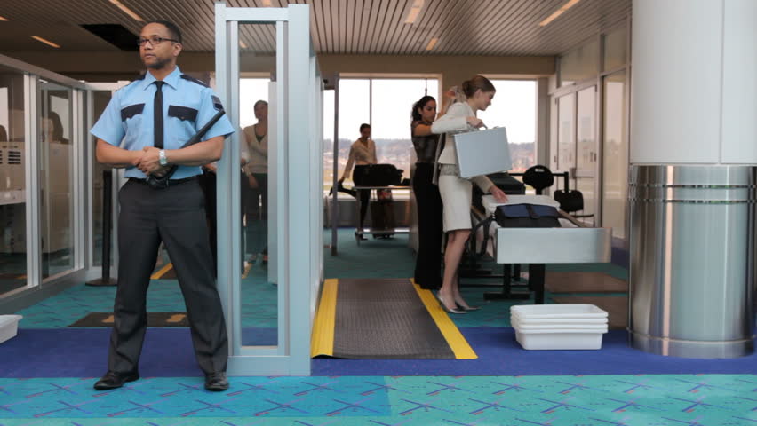 two-airport-security-guards-standing-in-front-of-metal-detector-stock