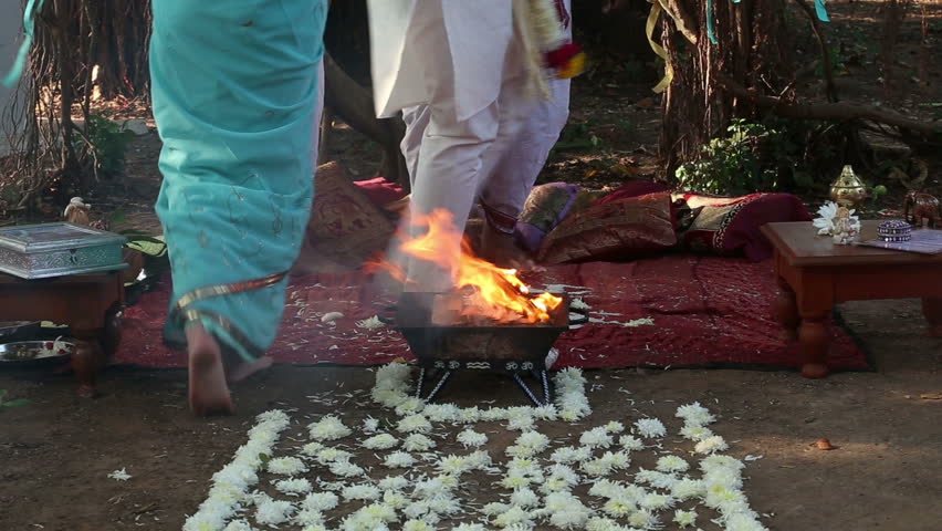 Bride And Groom Walk Around The Sacred Fire At The Indian Wedding Ceremony And They Throw Rose