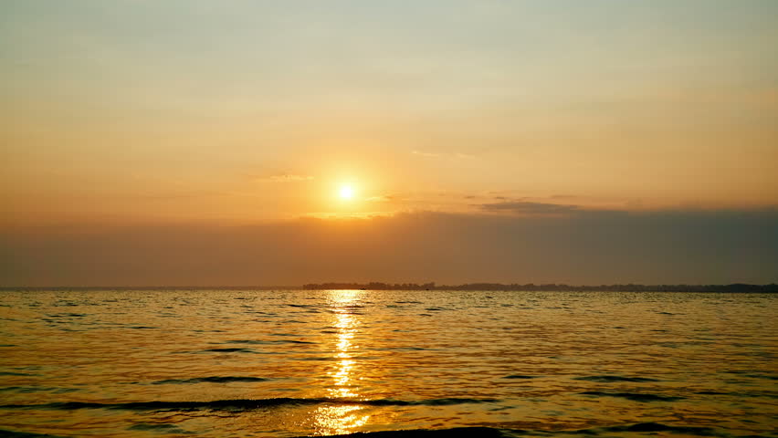 4K. The Bright Sun Is Setting Over Water With Gentle Waves. Time-lapse ...